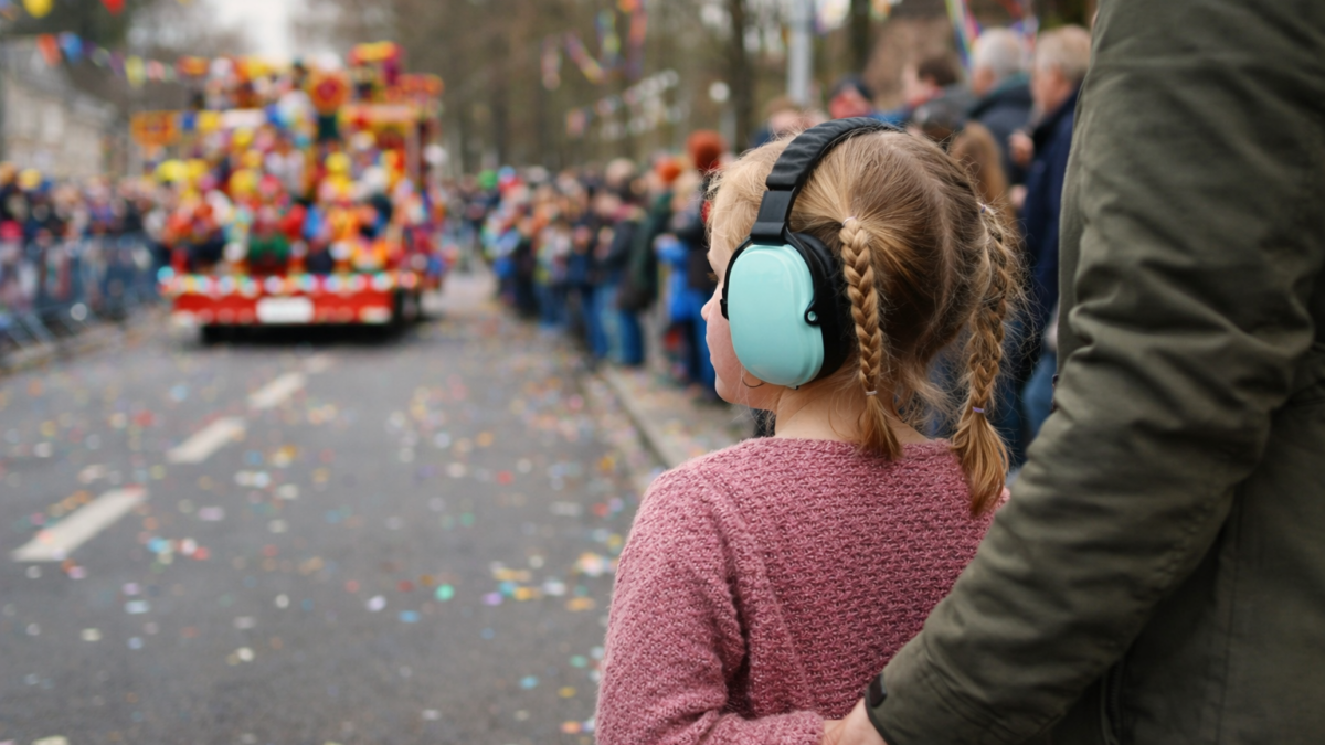 Kind met gehoorbescherming bij carnavalsoptocht – prikkelarm carnaval en autisme