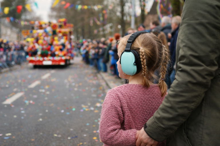 Kind met gehoorbescherming bij carnavalsoptocht – prikkelarm carnaval en autisme