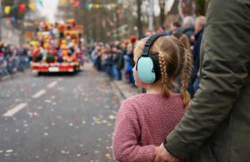 Kind met gehoorbescherming bij carnavalsoptocht – prikkelarm carnaval en autisme